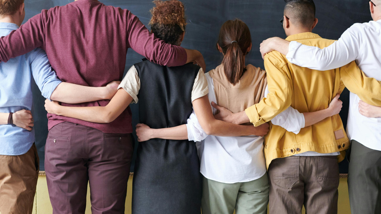 équipe collègues de travail bras dessus bras dessous et de dos